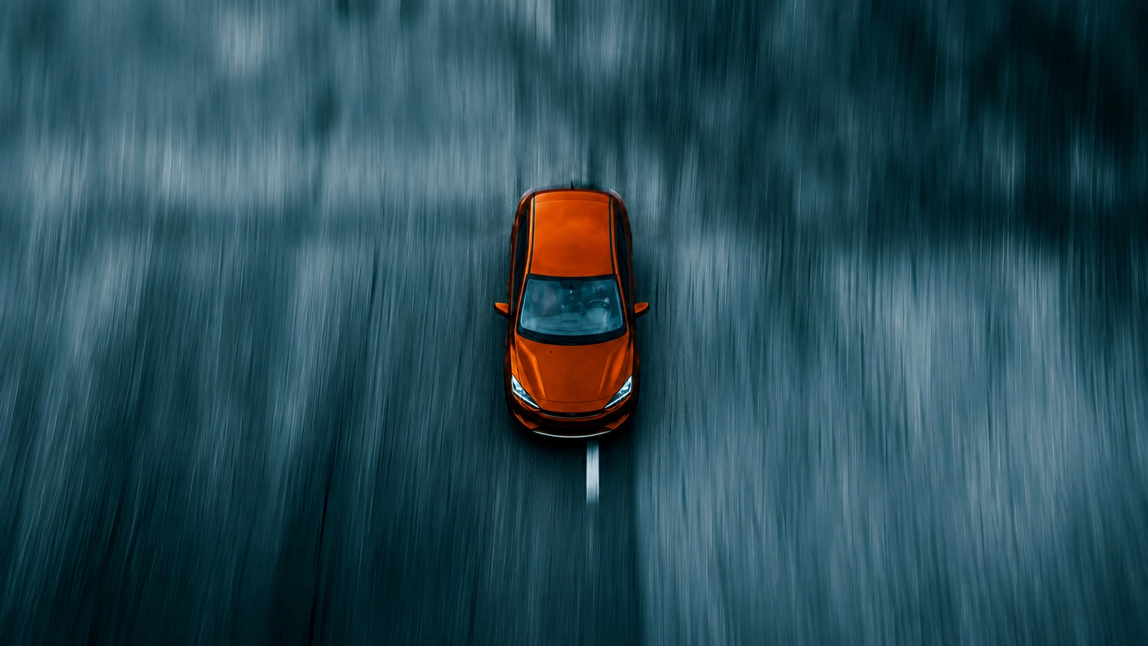 Vista cenital de un coche naranja en movimiento